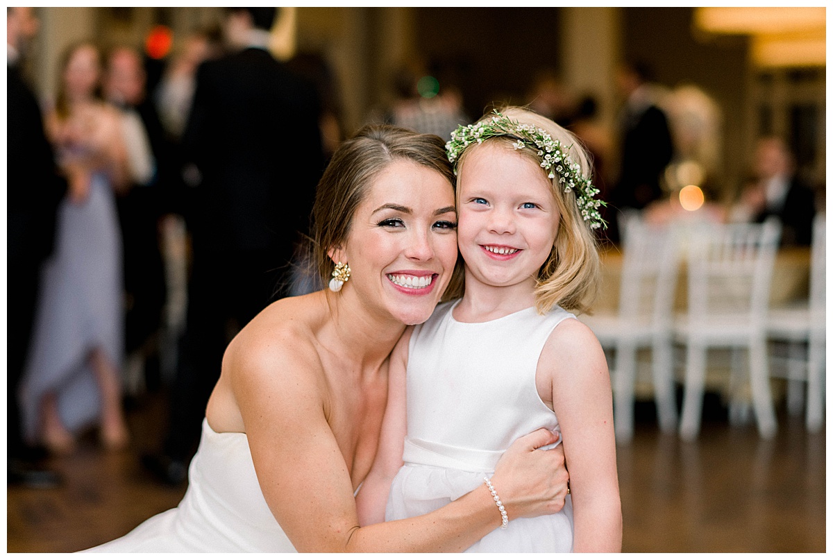 Bride smiles with flower girl